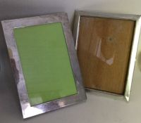 Two plain rectangular silver picture frames with p