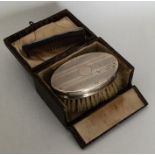 An Edwardian silver travelling brush and comb set
