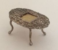 A small silver filigree doll's house table with ce