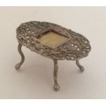 A small silver filigree doll's house table with ce