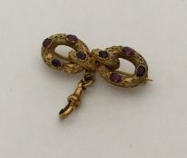 An Antique amethyst brooch in the form of a bow wi