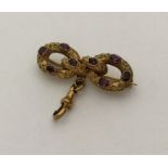 An Antique amethyst brooch in the form of a bow wi