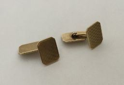 A pair of 14 carat gold engine turned cufflinks. A