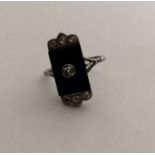 An Art Deco onyx and diamond cluster ring with lar