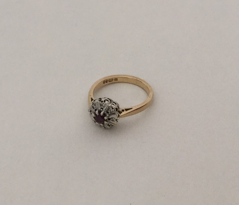 A ruby and diamond circular cluster ring in 9 cara