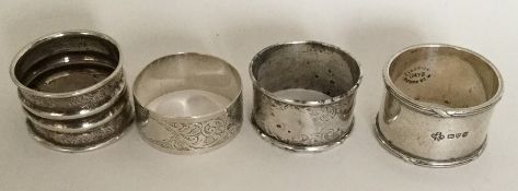 A group of four silver engraved napkin rings. Vari