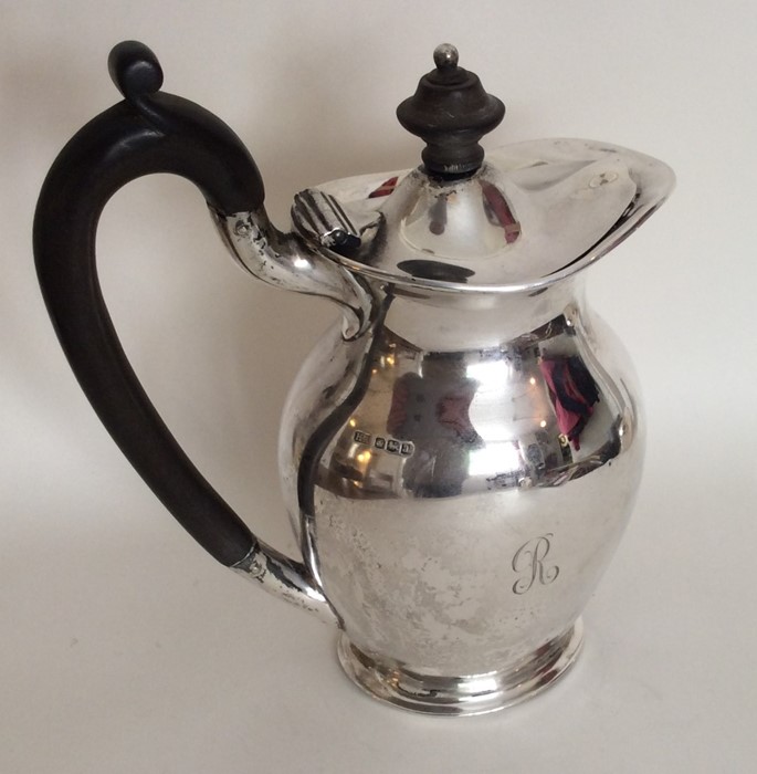 A silver baluster shaped water jug with hinged top
