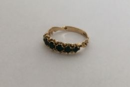 A 9 carat six stone emerald ring with ball decorat