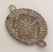 A silver filigree dish with scroll decoration. App