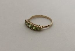 A 9 carat five stone peridot ring in claw mount. A