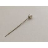 A single stone pearl mounted as a pin with twisted