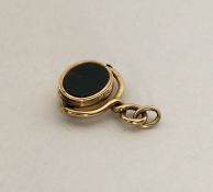 An unusual gold spinning fob set with blood stone