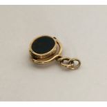 An unusual gold spinning fob set with blood stone