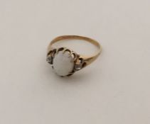 An opal and diamond gypsy set ring in claw mount.