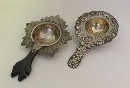 Two Continental silver tea strainers with floral d