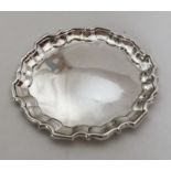 A small circular silver salver with shaped rim. Lo