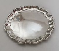 A small circular silver salver with shaped rim. Lo