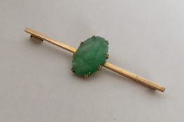 An Antique carved jade brooch set in high carat go