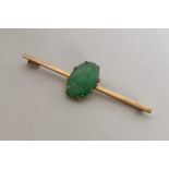 An Antique carved jade brooch set in high carat go