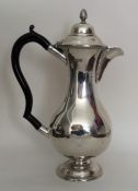 A slender silver hot water jug with gadroon rim. L