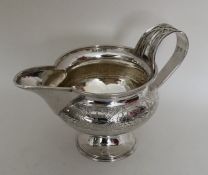 A good quality silver cream jug with strap work ha