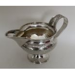 A good quality silver cream jug with strap work ha