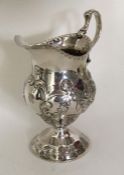 A Georgian silver cream jug decorated with flowers
