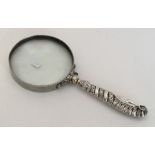 A large silver mounted magnifying glass with twist