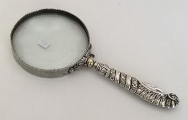 A large silver mounted magnifying glass with twist