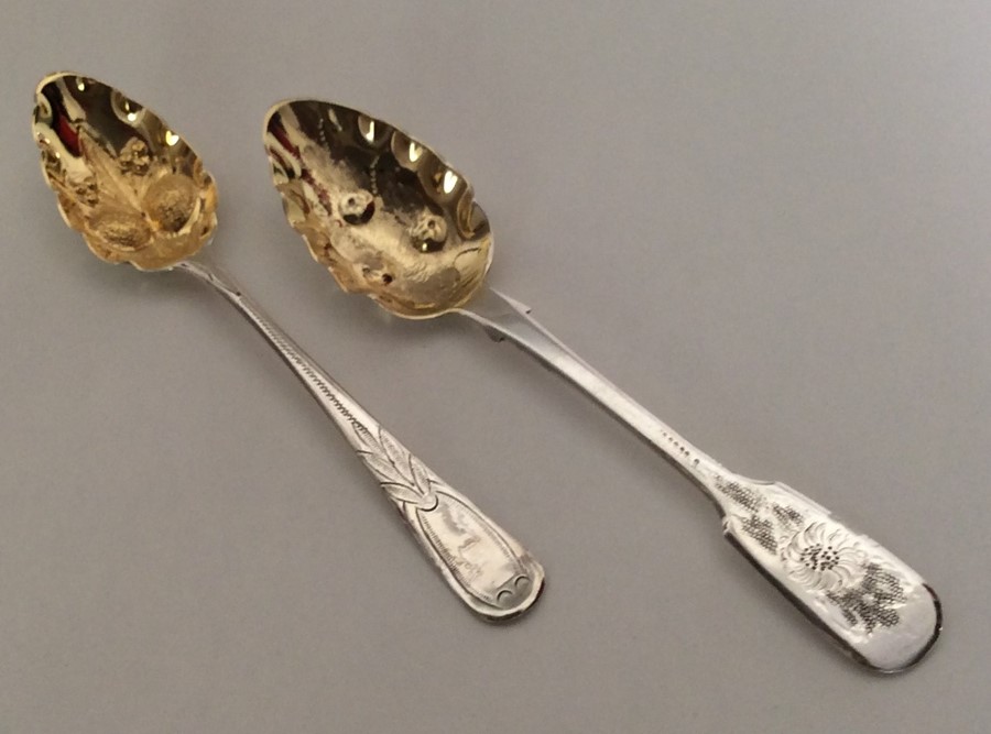 Two Georgian silver berry spoons with gilt bowls.