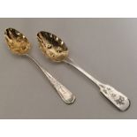 Two Georgian silver berry spoons with gilt bowls.