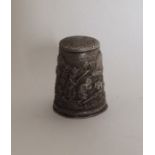 An unusual large chased silver thimble. Approx. 8