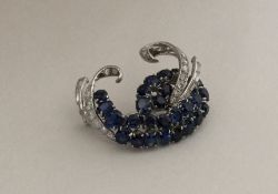 A stylish French sapphire and diamond brooch in cl