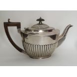 A heavy silver half fluted teapot. London. Approx.