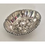 An oval silver bonbon dish attractively decorated