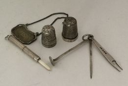 A silver thimble together with extending toothpick