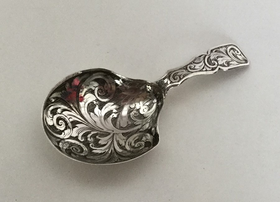 An Antique silver caddy spoon engraved with scroll
