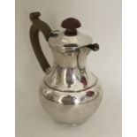 An Edwardian silver jug with hinged lid. London 19