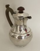 An Edwardian silver jug with hinged lid. London 19