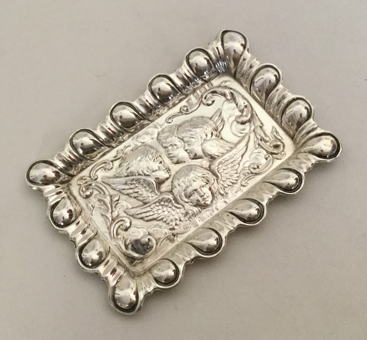 A rectangular silver pin tray mounted with cherubs