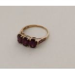 An amethyst three stone ring in 9 carat mount. App