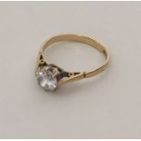 A 9 carat single stone ring in two colour setting.