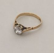 A 9 carat single stone ring in two colour setting.