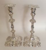 A good pair of George II cast silver candlesticks