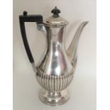 A heavy silver coffee pot of half fluted design. L