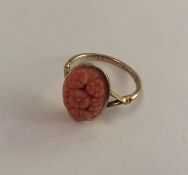 A 9 carat carved coral ring decorated with flowers