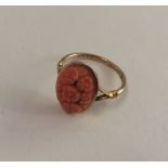 A 9 carat carved coral ring decorated with flowers