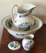 A decorative jug and basin set with floral decorat