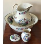 A decorative jug and basin set with floral decorat