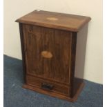 An Edwardian oak smoker's companion with fitted in